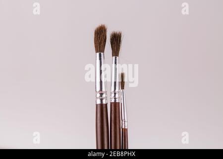 une brosse en bois pour peindre sur un fond blanc dans un porte-gobelet Banque D'Images