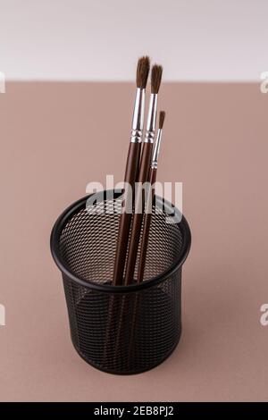 une brosse en bois pour peindre sur un fond blanc dans un porte-gobelet Banque D'Images