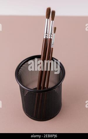 une brosse en bois pour peindre sur un fond blanc dans un porte-gobelet Banque D'Images