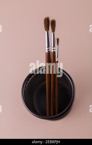 une brosse en bois pour peindre sur un fond blanc dans un porte-gobelet Banque D'Images