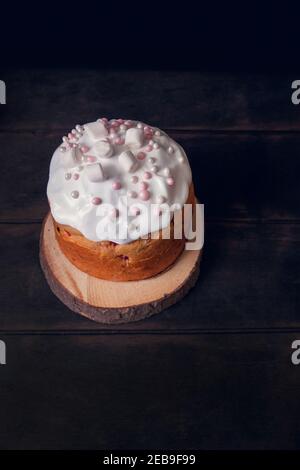 Gâteaux de Pâques sur un support en bois décoré de guimauves, fond sombre. Banque D'Images