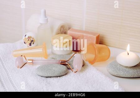 Concept de spa et d'auto-soins confortable. Divers outils de spa dans la salle de bains à la maison: Outil de laminage de face de quartz rose, outils de trempage de silicone pour le visage et le corps. Banque D'Images