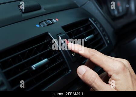 Fermez la main appuyez sur la lumière d'urgence dans la voiture, appuyez avec les doigts sur le bouton.pour ouvrir la lumière d'urgence du contrat dans la voiture. Appuyer sur le bouton d'urgence pour ouvrir Banque D'Images