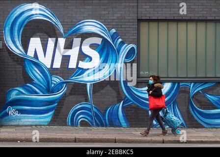 Londres, Royaume-Uni. 12 février 2021. Une femme passe devant une fresque du NHS dans l'est de Londres. Avec le Royaume-Uni à Lockdown, les gens ont exprimé leur admiration et leur amour pour le National Health Service. Crédit : Mark Thomas/Alay Live News Banque D'Images