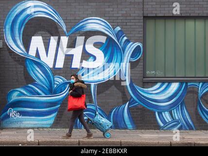 Londres, Royaume-Uni. 12 février 2021. Une femme passe devant une fresque du NHS dans l'est de Londres. Avec le Royaume-Uni à Lockdown, les gens ont exprimé leur admiration et leur amour pour le National Health Service. Crédit : Mark Thomas/Alay Live News Banque D'Images