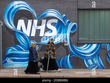 Londres, Royaume-Uni. 12 février 2021. Deux femmes marchent devant une fresque du NHS dans l'est de Londres. Avec le Royaume-Uni à Lockdown, les gens ont exprimé leur admiration et leur amour pour le National Health Service. Crédit : Mark Thomas/Alay Live News Banque D'Images