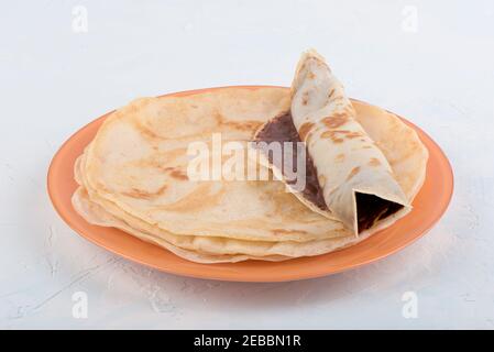 Crêpes roulées aux noix de chocolat sur une pile de crêpes. Gros plan. Banque D'Images