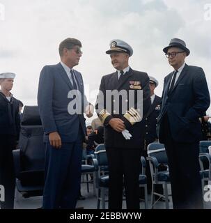 Voyage aux États de l'Ouest : visite de la flotte du Pacifique, le président Kennedy à bord de l'USS Kitty Hawk, 5:00. Le président John F. Kennedy (à gauche, portant des lunettes de soleil) visite le commandant en chef de la flotte du Pacifique (CINCPACFLT), l'amiral John H. Sides (au centre) à bord du porte-avions USS Kitty Hawk (CVA-63), au large de la côte de San Diego, en Californie; le secrétaire de la Marine, Fred Korth, se trouve à droite. Banque D'Images