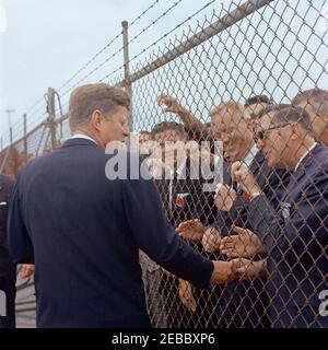 Voyage dans les États de l'Ouest : San Diego, Californie, arrivée à Lindbergh Field, convoi de voitures et adresse de commencement au San Diego State College. Le président John F. Kennedy (à gauche, en train de serrer la main avec un homme non identifié à travers une barrière à maillons de chaîne) salue les spectateurs qui se sont rassemblés pour son arrivée au champ de Lindbergh à San Diego, en Californie. Banque D'Images