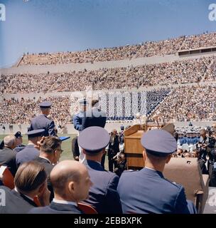 Voyage aux États de l'Ouest : le président Kennedy à l'Académie de l'US Air Force (USAF), Colorado. Le président John F. Kennedy (au centre de la plate-forme des haut-parleurs 0027s, dos à la caméra) se serre la main avec un cadet non identifié lors des exercices de commencement pour la cinquième classe de diplômés de l'Académie de l'Armée de l'Air des États-Unis (USAF); le président Kennedy a prononcé un discours pour l'occasion. Stade Falcon, USAF Academy, Colorado Springs, Colorado. Banque D'Images