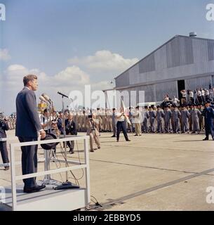 Visite d'inspection des installations de la NASA : Huntsville Alabama, Redstone Army Airfield et George C. Marshall Space Flight Centre, 9:35. Le président John F. Kennedy (à micros, chapeau de main) prononce un discours à des étudiants internationaux de l'École américaine de missiles guidés Ordnance, après son arrivée à l'aérodrome de l'Armée de Redstone, Redstone Arsenal, Huntsville, Alabama ; les photographes sont au premier plan. Le président Kennedy a visité Redstone Arsenal dans le cadre d'une visite d'inspection de deux jours des installations de l'Administration nationale de l'aéronautique et de l'espace (NASA). Banque D'Images