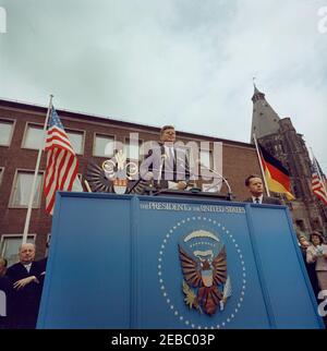 Voyage en Europe: Allemagne, Cologne: Ku00f6lner Rathaus (hôtel de ville), 10:55. Le président John F. Kennedy prononce une allocution devant Ku00f6lner Rathaus (hôtel de ville) à Cologne, Allemagne de l'Ouest (République fédérale); le directeur de la radio dans le secteur américain (RIAS) à Berlin et le traducteur du président Kennedy, Robert Lochner, est à droite du président. Droit permanent de la plate-forme speakersu2019: Adjoint au secrétaire d'État adjoint aux Affaires européennes, William R. Tyler; Eunice Kennedy Shriver. Banque D'Images