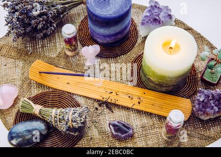 Petit bon feng Shui autel à la maison sur le seuil de fenêtre sur la table en forme de feuille tapis, la nature nordique enneigée sur fond. Bougie d'Encens fumeur, pierres gemmes pour de Banque D'Images