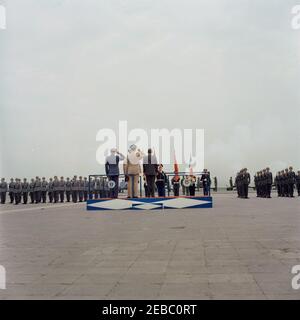 Voyage en Europe: Allemagne, Hanau: Arrivée à Fliegerhorst Kaserne, adresse, et inspection des troupes et du matériel, 10:45. Le Président John F. Kennedy (au centre, à la caméra) se tient sur une plate-forme de révision lors de sa cérémonie d'arrivée à Fliegerhorst Kaserne à Hanau, Allemagne de l'Ouest (République fédérale). Le personnel militaire est à l'attention. Banque D'Images