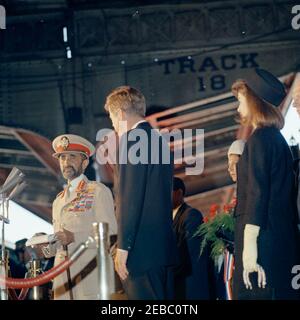 Cérémonie d'arrivée pour Haile Selassie I, empereur d'Éthiopie, 12:00. L'empereur d'Éthiopie, Haile Selassie I, prononce des remarques lors d'une cérémonie d'arrivée en son honneur; observe le président John F. Kennedy. La première dame Jacqueline Kennedy et la princesse Hirut u201cRuthu201d Desta, petite-fille de l'empereur Selassie, se tiennent à droite; le sous-secrétaire d'État américain, George ball, se trouve à l'extrême droite du cadre. Union Station, Washington, D.C. Banque D'Images