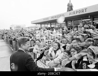 Voyage aux États de l'Ouest : Pierre, Dakota du Sud (barrage d'Oahe), 10:25. Le président John F. Kennedy accueille les foules à son arrivée à l'aéroport municipal de Pierre à Pierre, Dakota du Sud; le président Kennedy s'est rendu au Dakota du Sud pour assister à l'inauguration du barrage et du réservoir d'Oahe. Banque D'Images