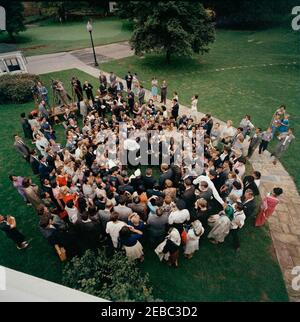 Visite des participants à l'expérience dans International Living, 12:00. Le président John F. Kennedy (vu d'en haut, dans la foule au centre à droite) visite des participants au programme expérience de vie internationale. Également en photo : Asha Mirchandani; photographe du National Park Service (NPS), Abbie Rowe; chef de la police de la Maison Blanche, Major Ralph C. u0022Smokeyu0022 Stover; correspondante de la Maison Blanche pour United Press International (UPI), Helen Thomas; photographe de cinéma pour Columbia Broadcasting System (CBS), Tom J. Craven, Jr.; photographe de presse pour United Movietone, Thomas Banque D'Images