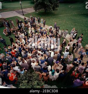 Visite des participants à l'expérience dans International Living, 12:00. Le président John F. Kennedy (vu d'en haut, au centre de la foule) visite des participants au programme expérience de vie internationale. Également en photo : Asha Mirchandani; photographe du National Park Service (NPS), Abbie Rowe; chef de la police de la Maison Blanche, Major Ralph C. u0022Smokeyu0022 Stover; correspondante de la Maison Blanche pour United Press International (UPI), Helen Thomas; photographe de cinéma pour Columbia Broadcasting System (CBS), Tom J. Craven, Jr.; Photographe de presse pour United Press Movietone, Thomas J. Cr Banque D'Images