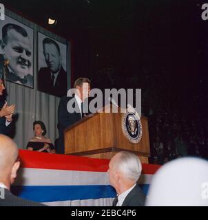 Voyage de campagne en Pennsylvanie. Le président John F. Kennedy assiste à un dîner de collecte de fonds démocrate à la Pennsylvania Farm Show Arena à Harrisburg, Pennsylvanie ; le président Kennedy s'est rendu à Harrisburg dans le cadre d'une campagne électorale du Congrès. Également photographié sur scène (G-D): Candidat pour le gouverneur de Pennsylvanie et ancien maire de Philadelphie, Richardson Dilworth (à l'extrême gauche); Secrétaire aux Affaires intérieures de Pennsylvanie, Geneviève Blatt. Banque D'Images