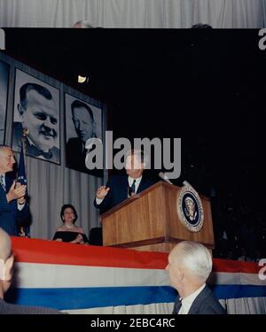 Voyage de campagne en Pennsylvanie. Le président John F. Kennedy assiste à un dîner de collecte de fonds démocrate à la Pennsylvania Farm Show Arena à Harrisburg, Pennsylvanie ; le président Kennedy s'est rendu à Harrisburg dans le cadre d'une campagne électorale du Congrès. Également photographié sur scène (G-D): Candidat pour le gouverneur de Pennsylvanie et ancien maire de Philadelphie, Richardson Dilworth (à l'extrême gauche); Secrétaire aux Affaires intérieures de Pennsylvanie, Geneviève Blatt. [Le haut du négatif contient la partie inférieure de KN-C24222.] Banque D'Images