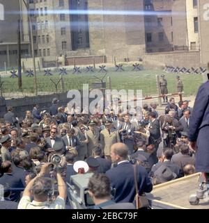 Voyage en Europe: Allemagne, Berlin-Ouest: Président Kennedy à Checkpoint Charlie, 12:05. Le président John F. Kennedy (au centre à gauche en premier plan, de retour à la caméra) visite le mur de Berlin près de Checkpoint Charlie à Berlin-Ouest, Allemagne de l'Ouest (République fédérale). Également en photo : le chancelier de l'Allemagne de l'Ouest, Konrad Adenauer; le maire de Berlin Ouest, Willy Brandt; Eunice Kennedy Shriver; le chef du protocole des États-Unis, Angier Biddle Duke; l'ambassadeur des États-Unis en Allemagne de l'Ouest, George C. McGhee; le secrétaire d'État des États-Unis, Dean Rusk; l'agent du service secret de la Maison Blanche, Gerald A. u201cJerryu201d Behn. Banque D'Images