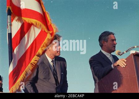 Voyage aux États de l'Ouest : El Paso, Texas. Le gouverneur du Texas, John Connally (à droite, debout au pupitre), prononce un discours lors d'une cérémonie d'arrivée en l'honneur du président John F. Kennedy à l'aéroport international d'El Paso, à El Paso, au Texas; le président Kennedy se trouve à gauche. [Remarques : les rayures et les imperfections sur l'ensemble de l'image sont originales au négatif.] Banque D'Images