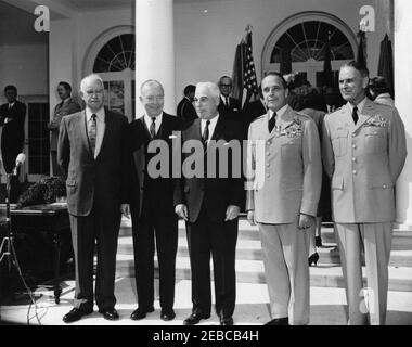 Cérémonie d'assermentation, général Maxwell Taylor, Président, JCS, 12 h 00. Le général Maxwell D. Taylor, récemment nommé Président des chefs d'état-major interarmées (JCS), se tient avec les anciens présidents du JCS au cours de sa cérémonie d'assermentation. De gauche à droite (en premier plan) : le général Omar Bradley; l'amiral Arthur W. Radford; le général Nathan F. Twining; le général Lyman L. Lemnitzer; le général Taylor. Le président John F. Kennedy (à l'arrière gauche, avec les armes repliées) et l'aide militaire au président, le général Chester V. Clifton, se trouvent dans la Colonnade de l'aile ouest. Également en photo : aide navale au président, capitaine Tazewell T. Shep Banque D'Images