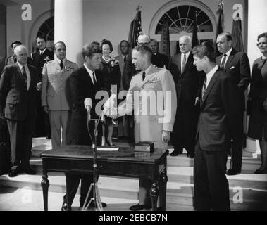 Cérémonie d'assermentation, général Maxwell Taylor, Président, JCS, 12 h 00. Le Président John F. Kennedy tremble la main avec le général Maxwell D. Taylor (au centre) lors de la cérémonie d'assermentation du général Tayloru0027s en tant que Président des chefs d'état-major interarmées (JCS); le Procureur général, Robert F. Kennedy, est à droite. En regardant les marches de la Colonnade de l'aile Ouest, en commençant tout à l'arrière (de gauche à droite): Aide aérienne au président, brigadier-général Godfrey T. McHugh (pour la plupart caché); général Omar Bradley; aide navale au président, capitaine Tazewell T. Shepard, Jr.; Président sortant du JCS, Gen Banque D'Images