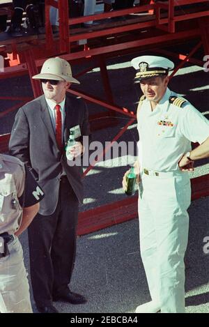 Voyage dans les États de l'Ouest : China Lake, Californie, (Naval Air Facility) NAF. Assistant spécial du Président John F. Kennedy, Kenneth P. Ou0027Donnell (à gauche, portant un chapeau de safari et tenant une bouteille de bière), Et de l'aide navale au Président, le capitaine Tazewell T. Shepard, Jr. (Également muni d'une bouteille de bière), observez les activités pendant la visite du Président Kennedyu0027s à la Naval Air Facility (NAF) China Laketu0027s Naval Ordnance Test Station (NOTS) à China Lake, Californie. [Remarques : les rayures sur toute l'image sont d'origine sur le négatif.] Banque D'Images