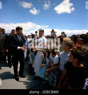 Voyage dans les États de l'Ouest : China Lake, Californie, (Naval Air Facility) NAF. Le président John F. Kennedy (à gauche, portant des lunettes de soleil) accueille les spectateurs rassemblés lors de sa visite à la NAF (NAF) China Lakeu0027s Naval Ordnance Test Station (NOTS) à China Lake, en Californie; les agents du service secret de la Maison Blanche, Charlie Kunkel, Roy Kellerman et Gerald A. u0022Jerryu0022 Behn, se trouvent à l'extrême gauche. Banque D'Images