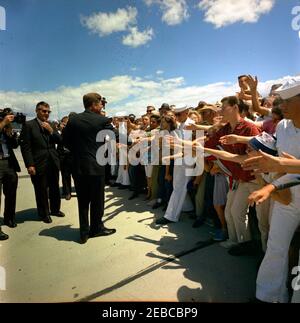 Voyage dans les États de l'Ouest : China Lake, Californie, (Naval Air Facility) NAF. Le président John F. Kennedy (à gauche, avec la main levée) accueille les spectateurs rassemblés lors de sa visite à la NAF (NAF) China Lakeu0027s Naval Ordnance Test Station (NOTS) à China Lake, Californie; Gerald A. u0022Jerryu0022 Behn, agent du service secret de la Maison Blanche, se trouve à gauche. Banque D'Images