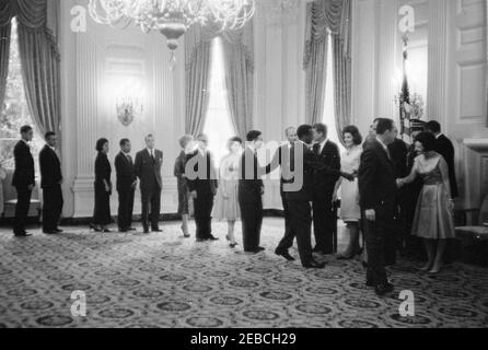 Réception diplomatique, 6:00. Le président John F. Kennedy, la première dame Jacqueline Kennedy et d'autres accueillent des invités sur la ligne de réception lors d'une réception diplomatique à la Maison Blanche. De gauche à droite : neuf personnes non identifiées, chef du Protocole Angier Biddle Duke, homme non identifié, président Kennedy, Mme Kennedy, vice-présidente Lyndon B. Johnson (pour la plupart caché), homme non identifié, Lady Bird Johnson. State Dining Room, White House, Washington, D.C. Banque D'Images