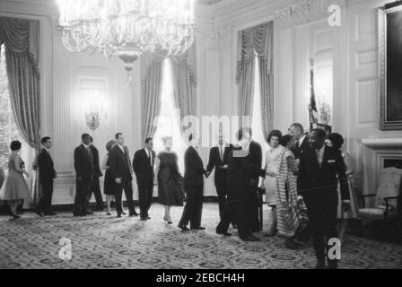 Réception diplomatique, 6:00. Le président John F. Kennedy, la première dame Jacqueline Kennedy et d'autres accueillent des invités sur la ligne de réception lors d'une réception diplomatique à la Maison Blanche. À droite : le chef du Protocole Angier Biddle Duke (qui se fait la main avec un homme non identifié), le président Kennedy (pour la plupart caché), Mme Kennedy, le vice-président Lyndon B. Johnson, Lady Bird Johnson (partiellement caché). Tous les autres sont non identifiés. State Dining Room, White House, Washington, D.C. Banque D'Images