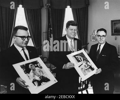 Visite des lauréats des Prix annuels de la White House News Photographers Association, 12:28PM. Le président John F. Kennedy visite les lauréats des prix annuels de la White House News Photographers Association, les photographes de Washington Star Walter M. u0022Ballyu0022 Oates (à gauche) et Randolph J. u0022Rannyu0022 Routt (à droite). Oval Office, Maison Blanche, Washington, D.C. Banque D'Images