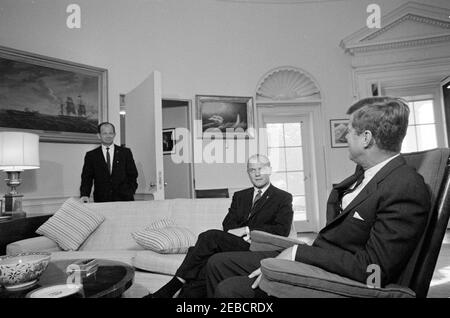 Rencontre avec l'astronaute John Herschel Glenn, Jr., 9 h 40. Le président John F. Kennedy (en fauteuil à bascule) rencontre l'astronaute colonel John H. Glenn, officier des affaires publiques de l'Administration nationale de l'aéronautique et de l'espace (NASA), le lieutenant-colonel John A. Powers, est à gauche. Oval Office, Maison Blanche, Washington, D.C. Banque D'Images