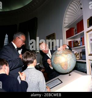 Réception pour l'astronaute John Herschel Glenn, Jr., 11:55. Tirant la route de son vol orbital, le lieutenant-colonel John H. Glenn Jr. (À droite) signe la Société géographique américaine Fliersu0027 et le Globe Explorersu0027 dans le Bureau ovale de la Maison Blanche lors d'une réception en son honneur. Regarder sur (G-D): Le neveu du président John F. Kennedyu0027s Robert F. Kennedy, Jr. (Retour à la caméra), le directeur de l'AGS Charles B. Hitchcock, et l'enfant non identifié (retour à la caméra). Banque D'Images