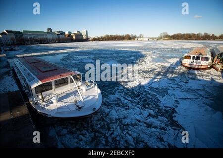 Hambourg, Allemagne. 12 février 2021. Les cuiseurs à vapeur Alster exploités par Alster-Touristik sont entourés de flotteurs de glace à leur jetée sur Jungfernstieg dans le Binnenalster. La couverture de glace des étangs et des lacs de Hambourg et du Schleswig-Holstein est encore mince malgré quelques jours de gel. Les autorités continuent de mettre en garde contre la marche sur la glace dans les eaux. (À dpa 'beau temps d'hiver au-dessus de Hambourg et Schleswig-Holstein') Credit: Christian Charisius/dpa/Alamy Live News Banque D'Images