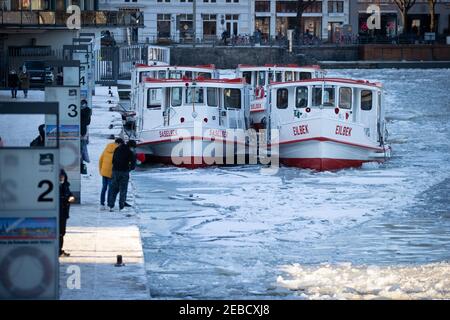 Hambourg, Allemagne. 12 février 2021. Les cuiseurs à vapeur Alster exploités par Alster-Touristik sont entourés de flotteurs de glace à leur jetée sur Jungfernstieg dans le Binnenalster. La couverture de glace des étangs et des lacs de Hambourg et du Schleswig-Holstein est encore mince malgré quelques jours de gel. Les autorités continuent de mettre en garde contre la marche sur la glace dans les eaux. (À dpa 'beau temps d'hiver au-dessus de Hambourg et Schleswig-Holstein') Credit: Christian Charisius/dpa/Alamy Live News Banque D'Images