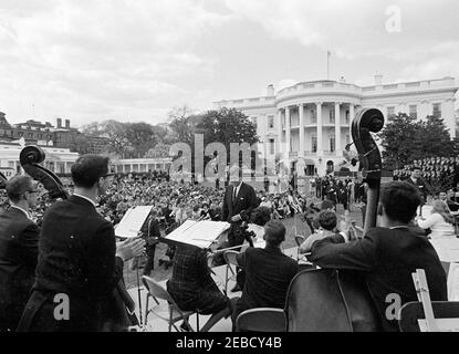 Programme musical pour les jeunes de la première Dame Jacqueline Kennedyu0027s (JBK), 14 h 35. Le président John F. Kennedy (au centre) quitte la scène après avoir prononcé des remarques à la troisième de la série First Lady Jacqueline Kennedyu0027s de programmes musicaux pour les jeunes par les jeunes. Le chef du Greater Boston Youth Symphony Orchestra (GBYSO), le Dr Marvin Rabin (à droite), est sur scène avec l'orchestre; les membres du Breckenridge Boys Choir sont en formation à l'extrême droite. South Lawn, Maison Blanche, Washington, D.C. Banque D'Images