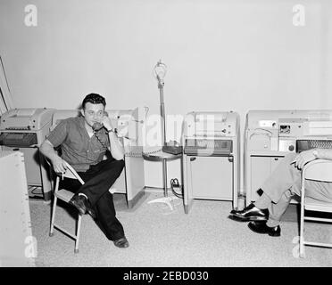 Voyage aux Bermudes : préparation de l'équipement de communication de l'Agence de signalisation de l'Armée de la Maison Blanche (WHASA), personnel et vues sur la ville. Le personnel de la White House Army signal Agency (WHASA) a mis en place du matériel de communication aux Bermudes pour les réunions du Président John F. Kennedyu2019s avec le Premier ministre Harold Macmillan de Grande-Bretagne; un homme non identifié parle au téléphone à gauche. [Photo de Dan Lewis] Banque D'Images