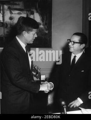 Cérémonie de signature, accord de 6,000,000 000 $ avec l'Organisation des États américains (OEA), 4:45. Le président John F. Kennedy et le Dr Josu00e9 Mora, secrétaire général de l'Organisation des États américains (OEA), se mettent à serrer la main lors de la signature d'un accord de 6 millions de dollars pour l'OEA. Bureau du Dr Morau2019s, immeuble de l'Union panaméricaine, Washington, D.C. Banque D'Images