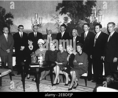 Présentation de pots de bonbons anciens à la Maison Blanche. L'Institut des bonbons, du chocolat et de la confiserie présente des pots de bonbons anciens (env. 1860) à la Maison Blanche. Letitia Baldrige, secrétaire sociale de la première dame Jacqueline Kennedy (assise sur le canapé, troisième à partir de la gauche); Lea Gallolic, représentante de l'industrie des bonbons (assise sur le canapé, troisième à partir de la droite); autres non identifiés. Salle de réception diplomatique, Maison Blanche, Washington, D.C. Banque D'Images