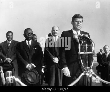 Cérémonies d'arrivée de William Vacanarat Shadrach Tubman, Président du Libéria, 10 h 00. Le président John F. Kennedy prononce des remarques lors des cérémonies d'arrivée de William V.S. Tubman, Président du Libéria. Le Président Kennedy (à micros); le Président Tubman et le Secrétaire d'État Dean Rusk (derrière le Président Kennedy); le Chef du Protocole Angier Biddle Duke (à droite de la plate-forme); d'autres non identifiés. Andrews Air Force base, Maryland. Banque D'Images