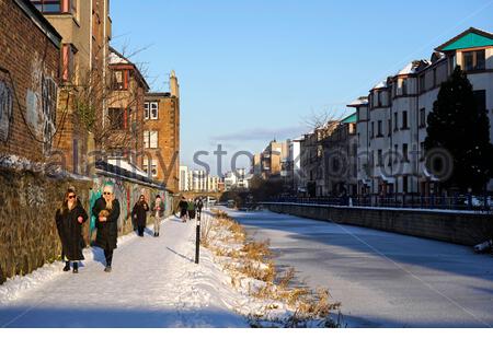 Édimbourg, Écosse, Royaume-Uni. 12 février 2021. Les gens apprécient un après-midi froid ensoleillé mais glacial le long du canal Union au bassin de Lochrin, avec le canal gelé solide avec de la glace. Crédit : Craig Brown/Alay Live News Banque D'Images