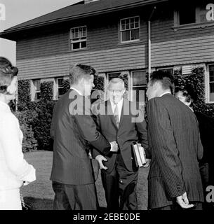 Week-end à Newport, Rhode Island : le président Kennedy est accueilli par James L. Maher, maire de Newport et sa femme. Le maire James L. Maher de Newport et son épouse Mary Maher accueillent la famille Kennedy à leur arrivée à Newport, Rhode Island. (G-D) la première Dame Jacqueline Kennedy; le président John F. Kennedy; le maire Maher; non identifié; Mme Maher (partiellement cachée). Banque D'Images