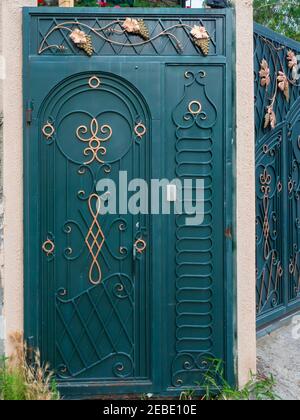 Porte en fer turquoise foncé avec motif corroyé et dorures Banque D'Images