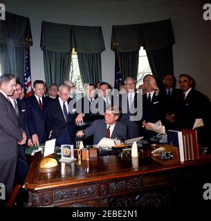 Signature du projet de loi - S. 1991 Loi publique 415, développement de la main-d'oeuvre u0026 Loi sur la formation, 10:31AM. Le président John F. Kennedy (assis à son bureau) remet des stylos après avoir signé la Loi sur le développement de la main-d'oeuvre et la formation (Loi publique 415). (G-D): Le congressiste Neal Smith (Iowa); le sénateur Maurice J. Murphy, Jr. (New Hampshire); le congressiste Charles S. Joelson (partiellement caché); le congressiste Charles E. Goodell (New York); le directeur du département de la législation de la Fédération américaine du travail et du Congrès des organisations industrielles (AFL-CIO), Andrew J. Biemiller; Membre du congrès Carroll D. Banque D'Images