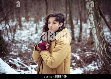 Fille avec des taches de rousseur se tient dans la neige couverte avant garde au chaud Banque D'Images