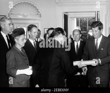 Cérémonie d'assermentation, délégation des États-Unis aux Nations Unies (ONU), 10:31AM. Le Président John F. Kennedy présente un point à l'Ambassadeur des États-Unis en Norvège, Clifton R. Wharton, Sr., lors de la cérémonie d'assermentation des représentants et des suppléants de la délégation des États-Unis à l'Assemblée générale des Nations Unies (ONU), Bureau ovale, Maison Blanche, Washington, D.C. en regardant (de gauche à droite): Jonathan Brewster Bingham, représentant des États-Unis au Conseil de tutelle de l'ONU; représentant Marguerite Stitt Church of Illinois; représentant adjoint au Conseil de sécurité de l'ONU Charles W. Yost; représentant Banque D'Images