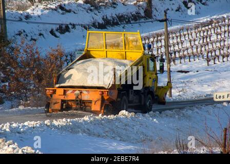 Le gritter fait accélérer sa charge sur une route entre vignobles dans le Languedoc, dans le sud de la France. Banque D'Images